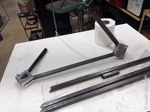 Two short and one long pieces of tube are held in the aluminum jigs